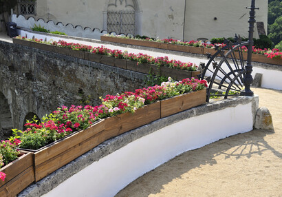 Blumenkästen auf der Brüstung der Eingangsbrücke